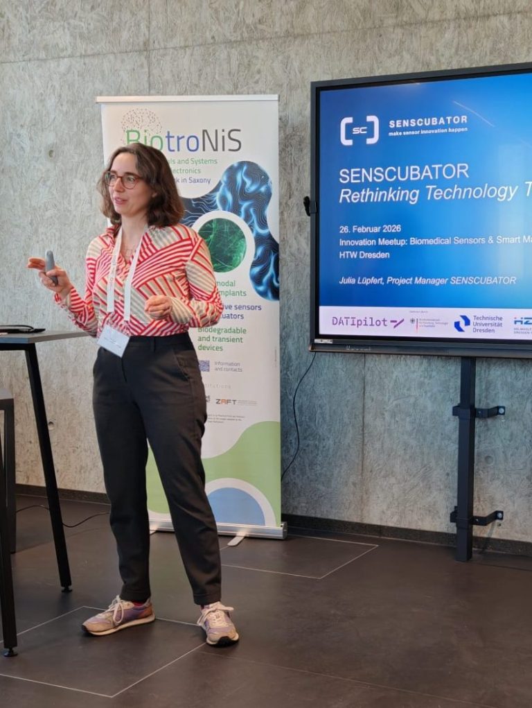 Frau präsentiert beim Workshop zur Technologie-Entwicklung vor einem Bildschirm.